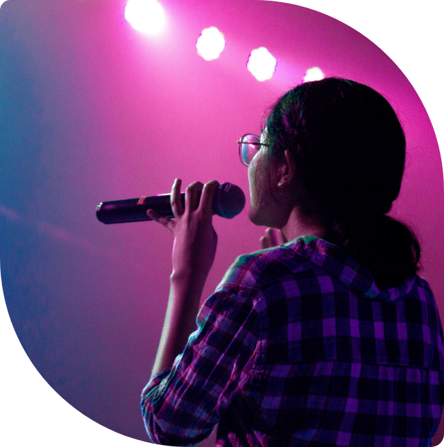 Photo d'une jeune femme de dos qui chante sur une scène