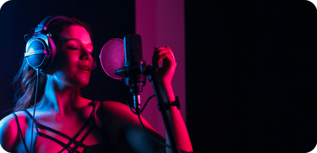 Jeune femme qui chante dans un studio dans une ambiance tamisée